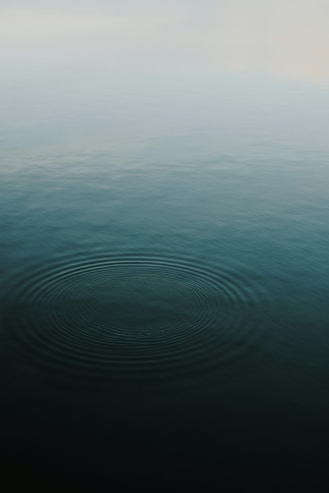 Ruhige Wasseroberfläche mit konzentrischen Kreisen – Sinnbild für Reflexion